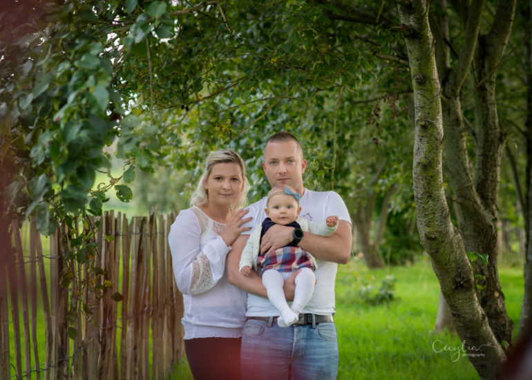 a couple holding a baby in the park