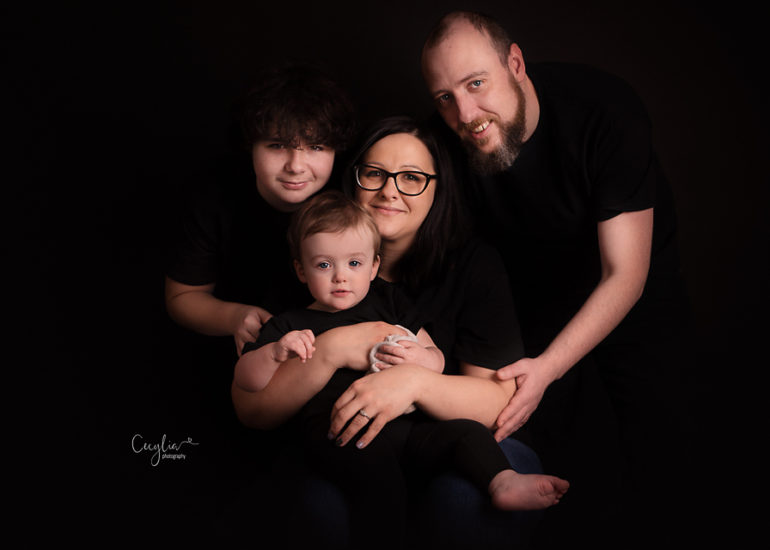 happy family on the black background in cecylia photography studio