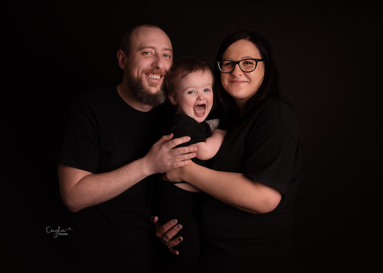 a baby boy with parents having fun on the photo session