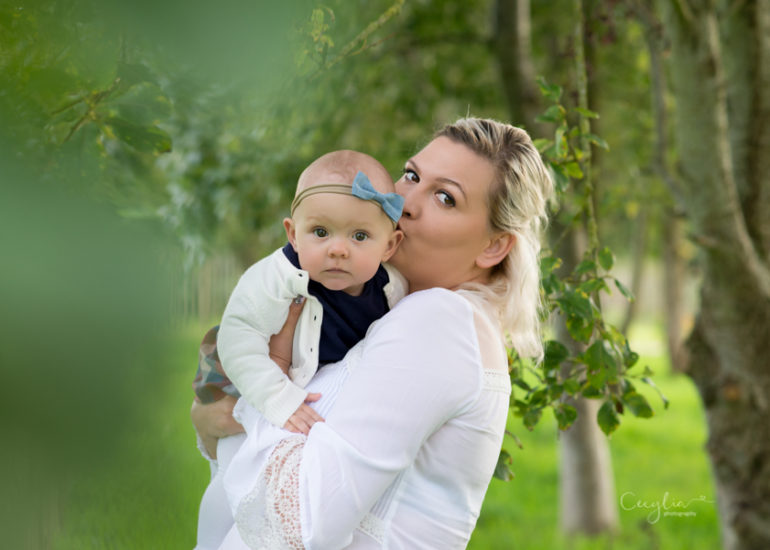 a mother holding a baby in the park