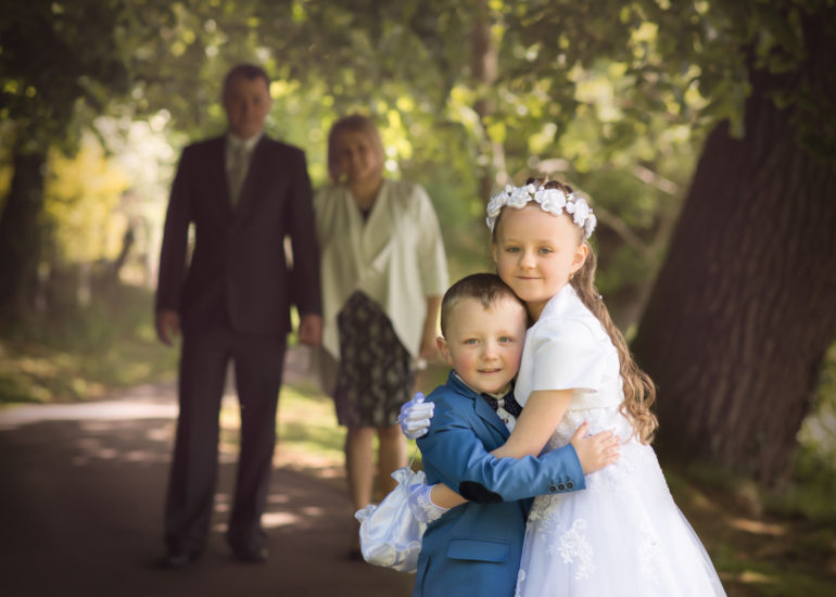 parents looking at the daughter on her fist holy communion