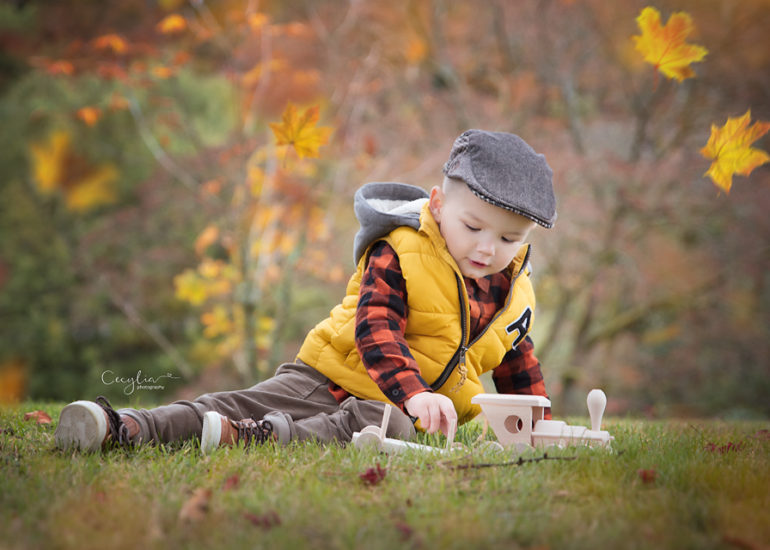 a boy playing with wooden train toy