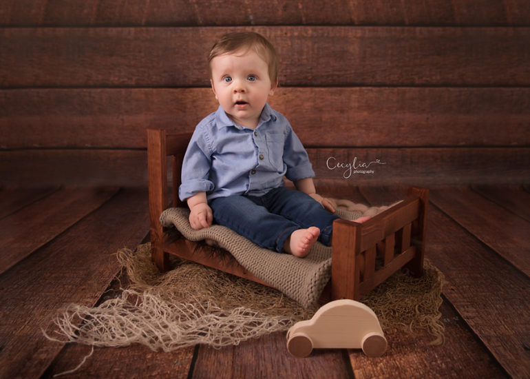 baby boy on bed in havoing fun on the sitters photo session