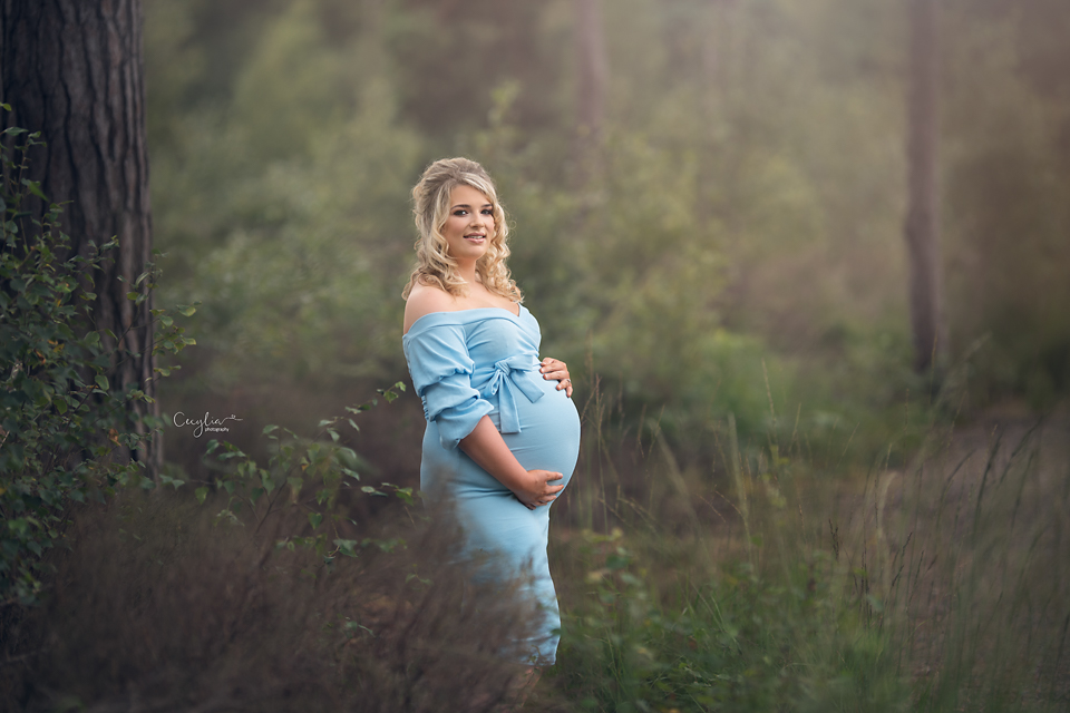 a pregnant women in blue dress in the park
