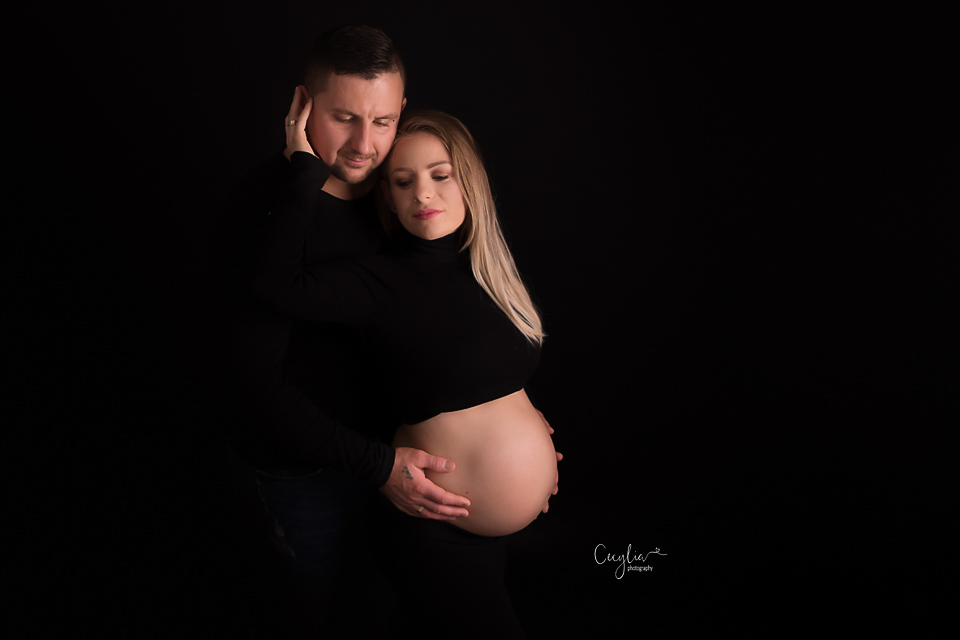 beautiful couple expecting a baby posing in black shirts