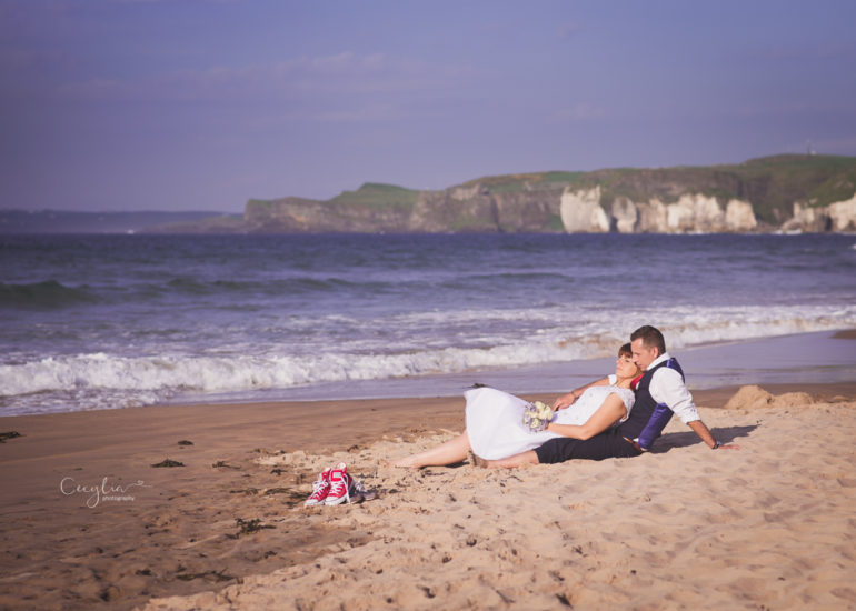 a couple laying on the sand by cecylia photography